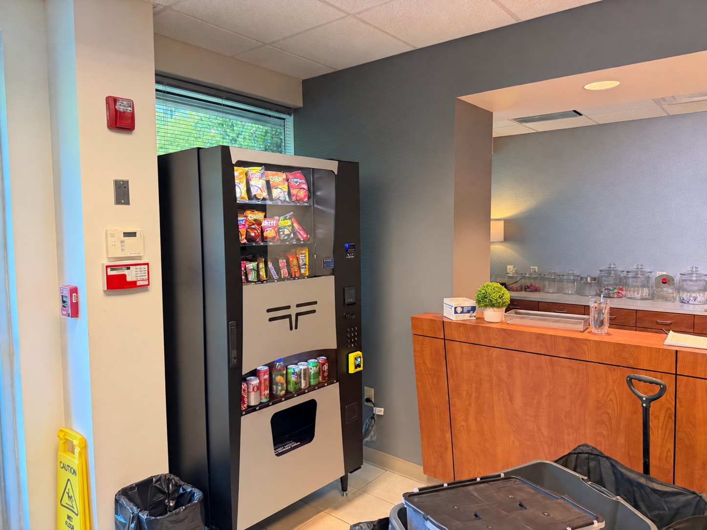 Stocked Blue Pearl combo vending machine installed beside a reception desk
