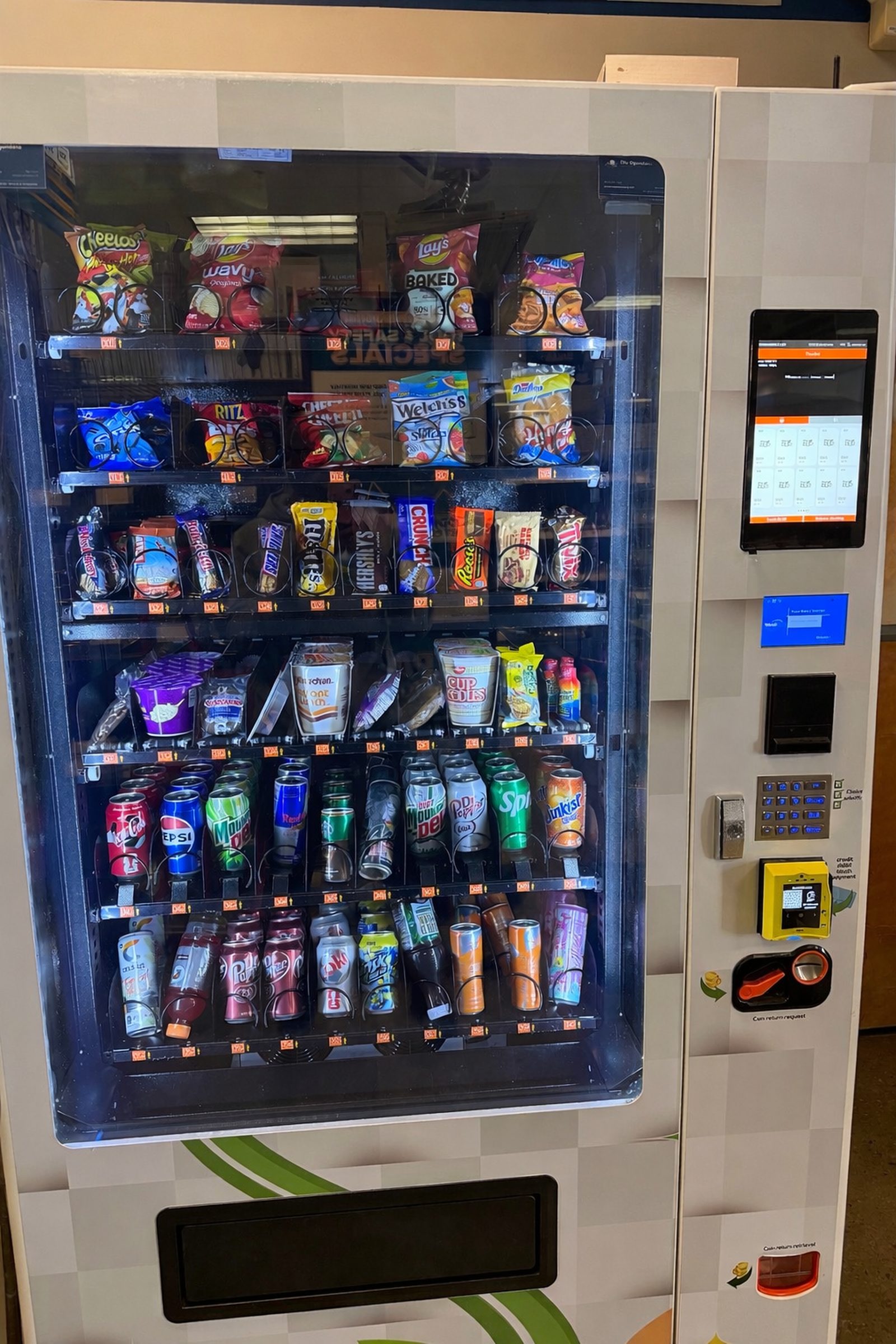 Blue Pearl vending machine fully stocked with Coca-Cola, Pepsi, Red Bull, chips, candy, and grab-and-go snacks at a Hampton Roads workplace